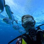 Scuba diver surrounded by schooling fish at Lighthouse Reef Atoll Belize