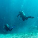 Scuba divers descending into the Great Blue Hole in Belize at Lighthouse Reef Atoll