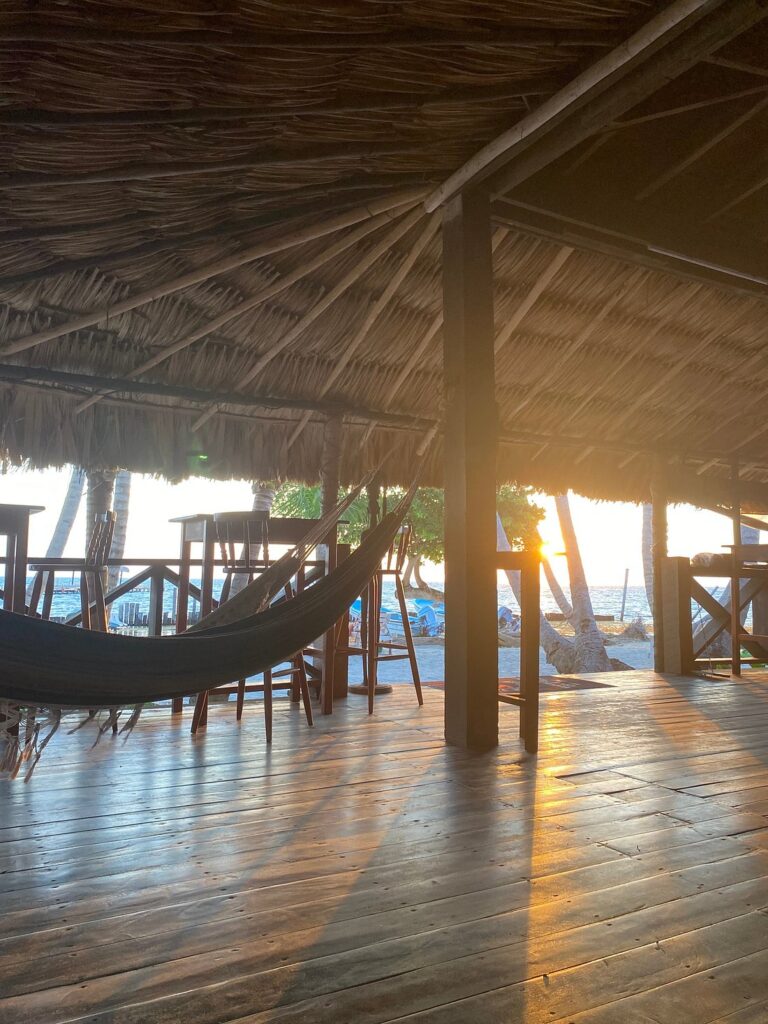 Open air dining and hammock at Itza Resort Lighthouse Reef Belize during sunrise