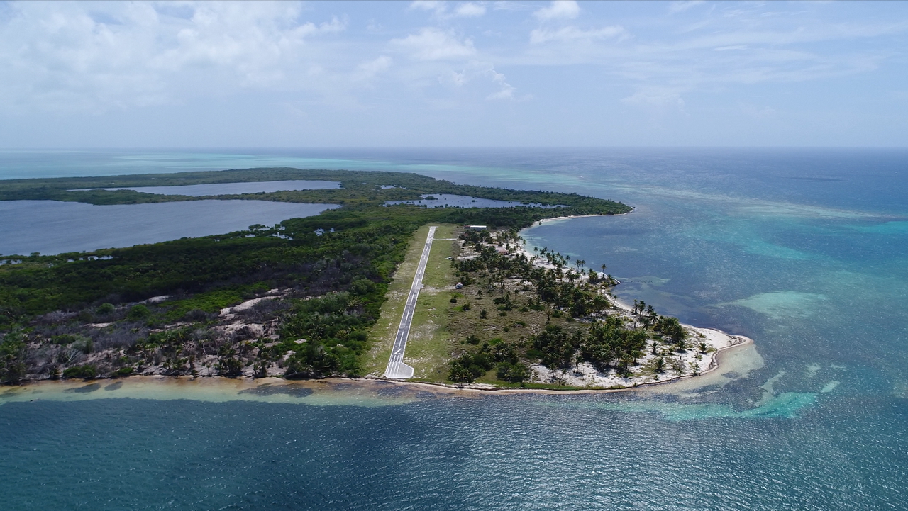 Aerial view of Northern Caye showing the airstrip and surrounding lagoon at Lighthouse Reef Atoll, Belize.